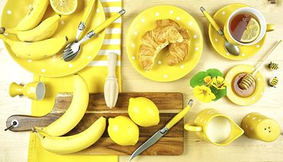 med, vidlička, kalíšeknavejce, citrón, slánka, smetana, čaj, prkénka, croissant, včela, banán, nůž, lžíce, talíř, žlutý
