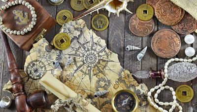 monetos, žemėlapis, ritinys, kompasas, dėžutė, kriauklės, buteliukas, perlai, inkaras, vėjųrožė, pypkė