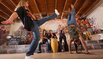 capoeira, hudobníci, džínsy, congabubon, tielko, berimbau, tamburína, dredy, grafiti, dlaň, stojka, kufor