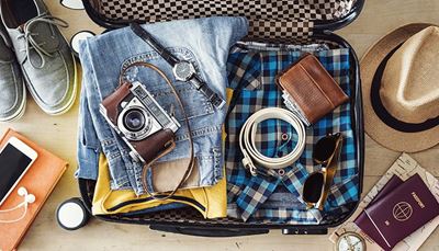 bőrönd, farmernadrág, kamera, pénztárca, fejhallgató, iránytű, öv, ing, térkép, útlevél