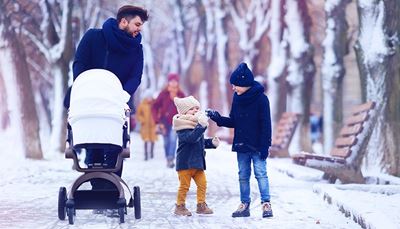 bench, winterjacket, snoodscarf, children, walking, passersby, stroller, snow, trees, hat