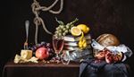 knot, pomegranate, tablecloth, stilllife, zest, apple, grapes, cheese, bread, rope, drink, books