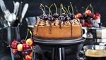 spongecake, cakestand, whippedcream, coffeepot, flatware, chocolate, coffee, cherry, cake