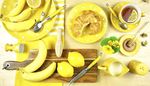 eggcup, cuttingboard, croissant, banana, saltshaker, yellow, honey, spoon, plate, fork, knife, tea, cream, bee, lemon