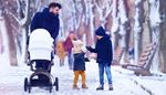 bench, winterjacket, snoodscarf, children, walking, passersby, stroller, snow, trees, hat